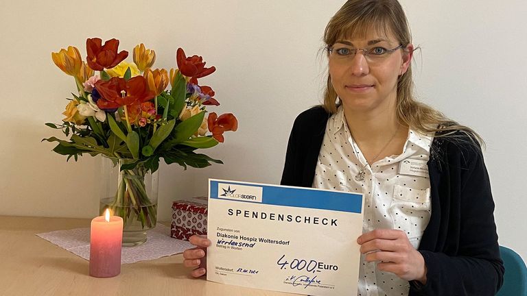 Diakonie Hospiz Woltersdorf - Pflegedienstleitung Stefanie Micklitza hält Spendenscheck von Förderverein Polarstern in der Hand Diakonie Hospiz Woltersdorf - Pflegedienstleitung Stefanie Micklitza hält Spendenscheck von Förderverein Polarstern in der Hand