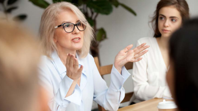 Mitarbeitende sitzen am Tisch, eine Frau spricht und gestikuliert, Weiterbildung, Fortbildungen für Mitarbeitende, Kursprogramm Albertinen Akademie 2025, Hamburg, Berlin